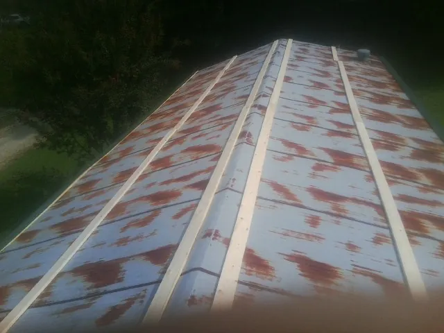Rusted metal roof panels with new wood purlins before replacement — Storm Damage Roof Repair in Yoakum by Roofing Brothers