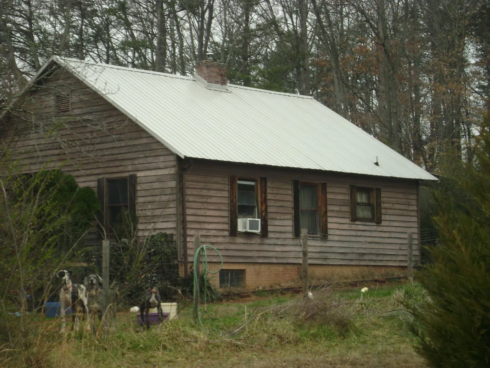 White metal roof on an old wood sided farmhouse, from a Metal Roof Installation job in Yoakum
